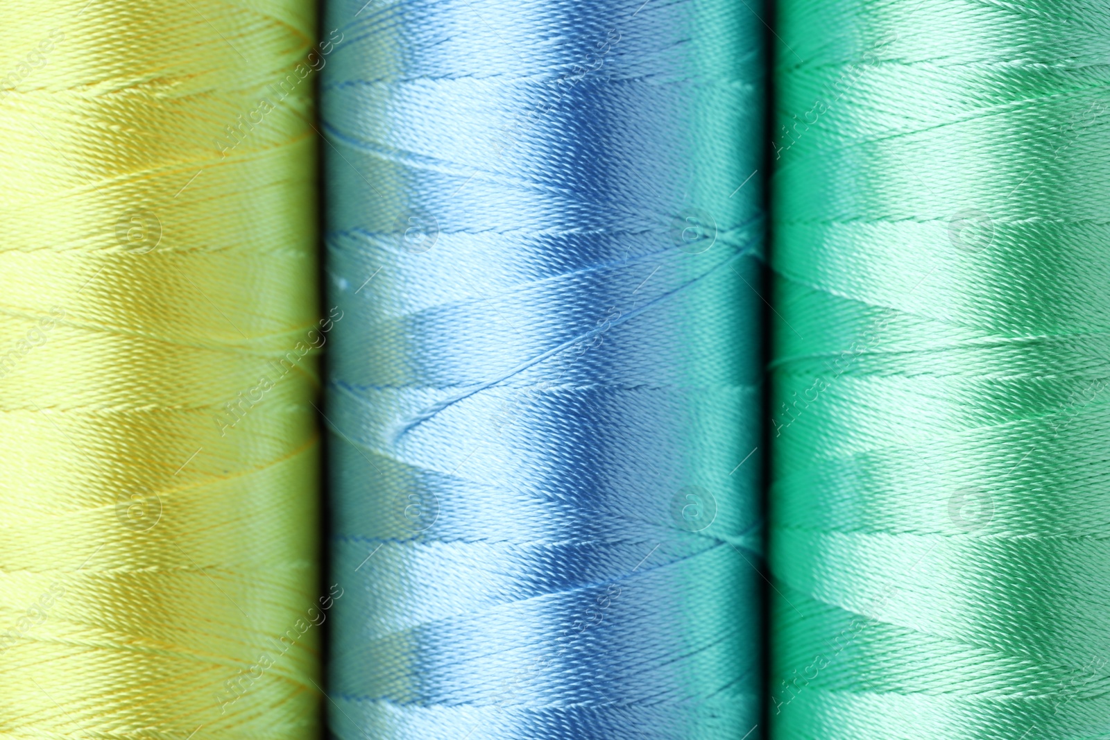 Photo of Spools of colorful sewing threads as background, top view