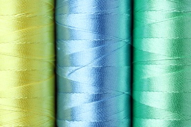 Photo of Spools of colorful sewing threads as background, top view