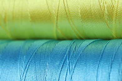 Photo of Spools of colorful sewing threads as background, closeup