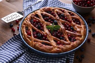 Photo of Delicious currant pie with fresh berries on wooden table