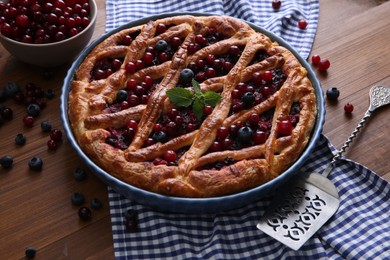 Photo of Delicious currant pie with fresh berries on wooden table