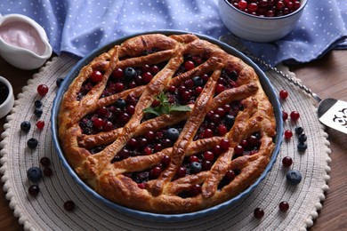 Photo of Delicious currant pie with fresh berries on wooden table