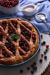 Photo of Delicious currant pie with fresh berries on wooden table