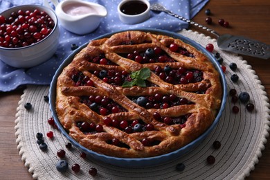 Photo of Delicious currant pie with fresh berries on wooden table