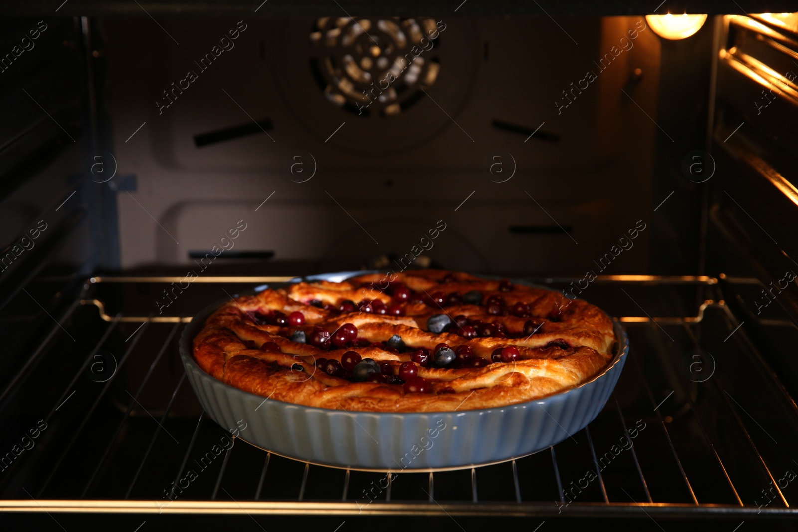 Photo of Delicious homemade currant pie in oven, closeup