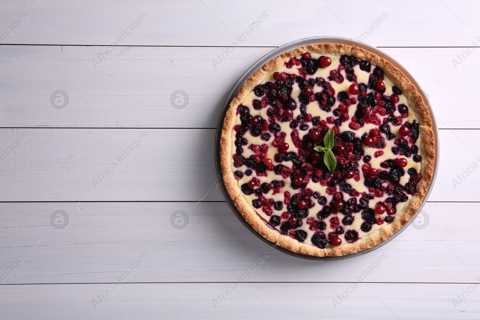 Photo of Delicious currant pie on white wooden table, top view. Space for text