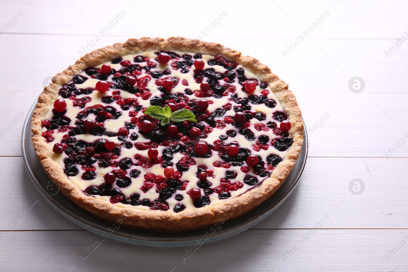 Photo of Delicious currant pie on white wooden table