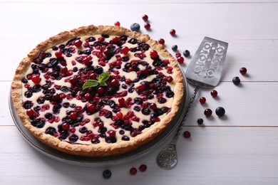 Photo of Delicious currant pie and fresh berries on white wooden table