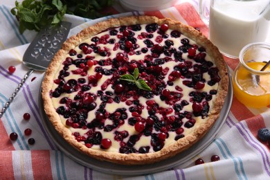 Photo of Delicious currant pie and fresh berries on kitchen towel