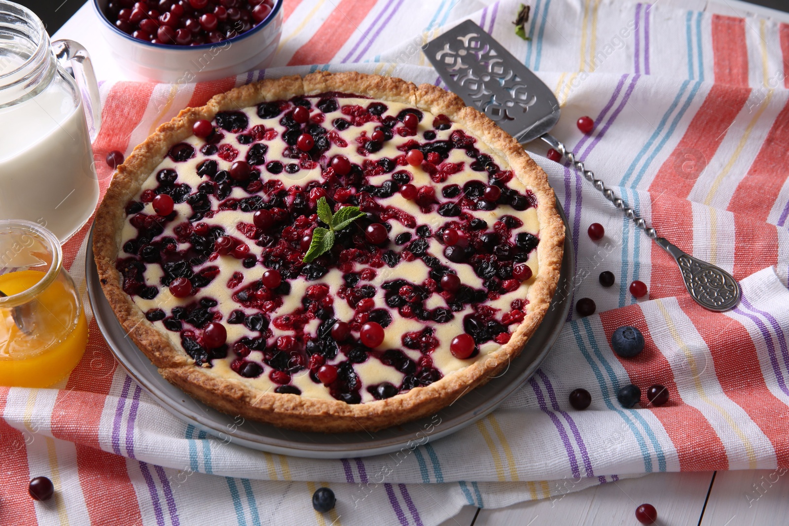 Photo of Delicious currant pie and fresh berries on kitchen towel