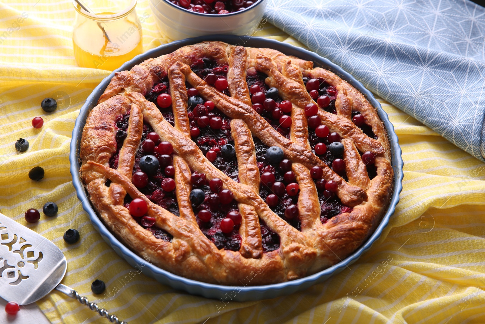 Photo of Delicious currant pie with fresh berries on tablecloth