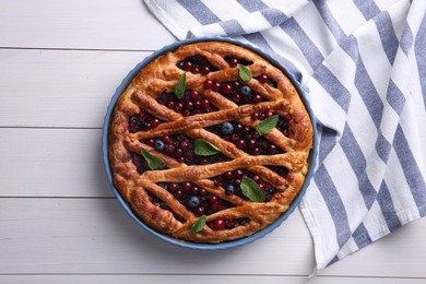 Photo of Delicious currant pie and fresh berries on white wooden table, flat lay