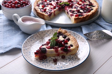 Photo of Piece of delicious currant pie served on white wooden table