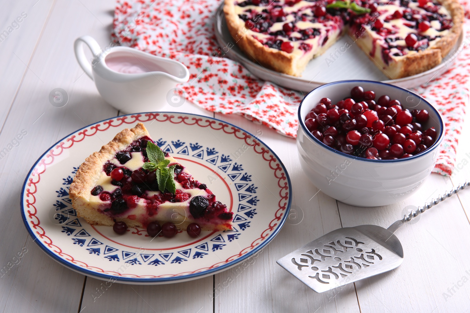 Photo of Piece of delicious currant pie served on white wooden table