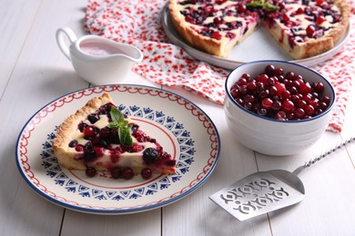 Photo of Piece of delicious currant pie served on white wooden table