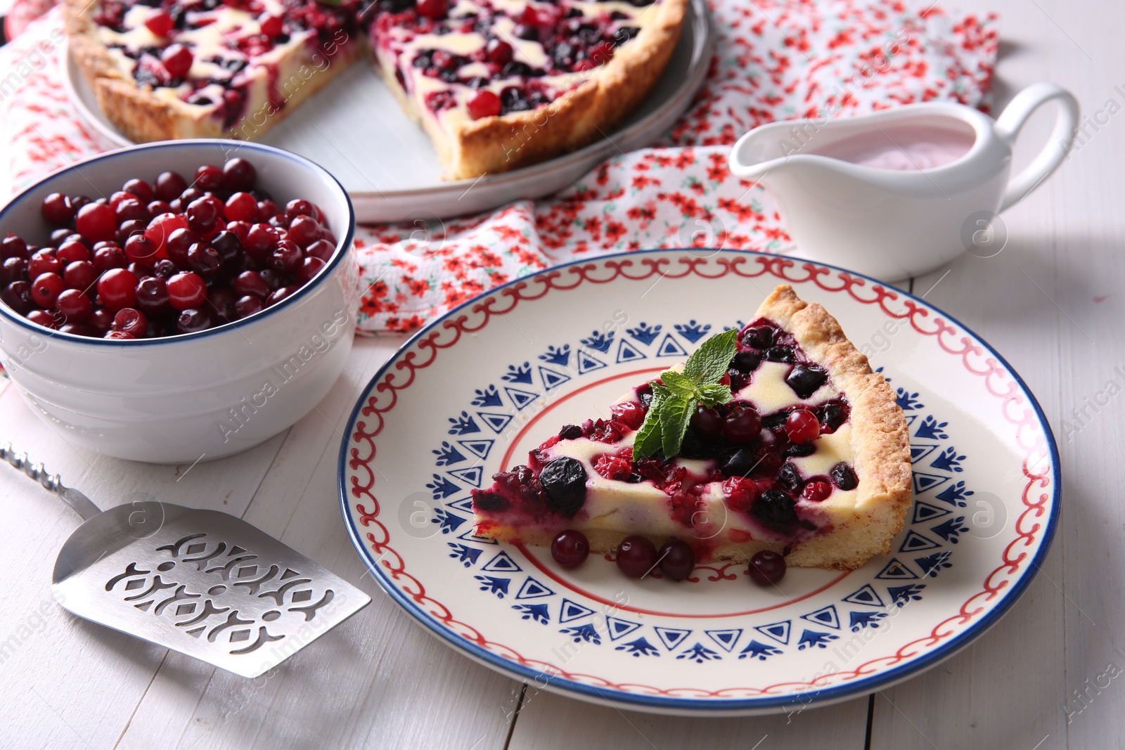 Photo of Piece of delicious currant pie served on white wooden table