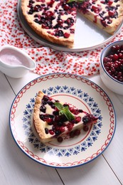 Photo of Piece of delicious currant pie served on white wooden table