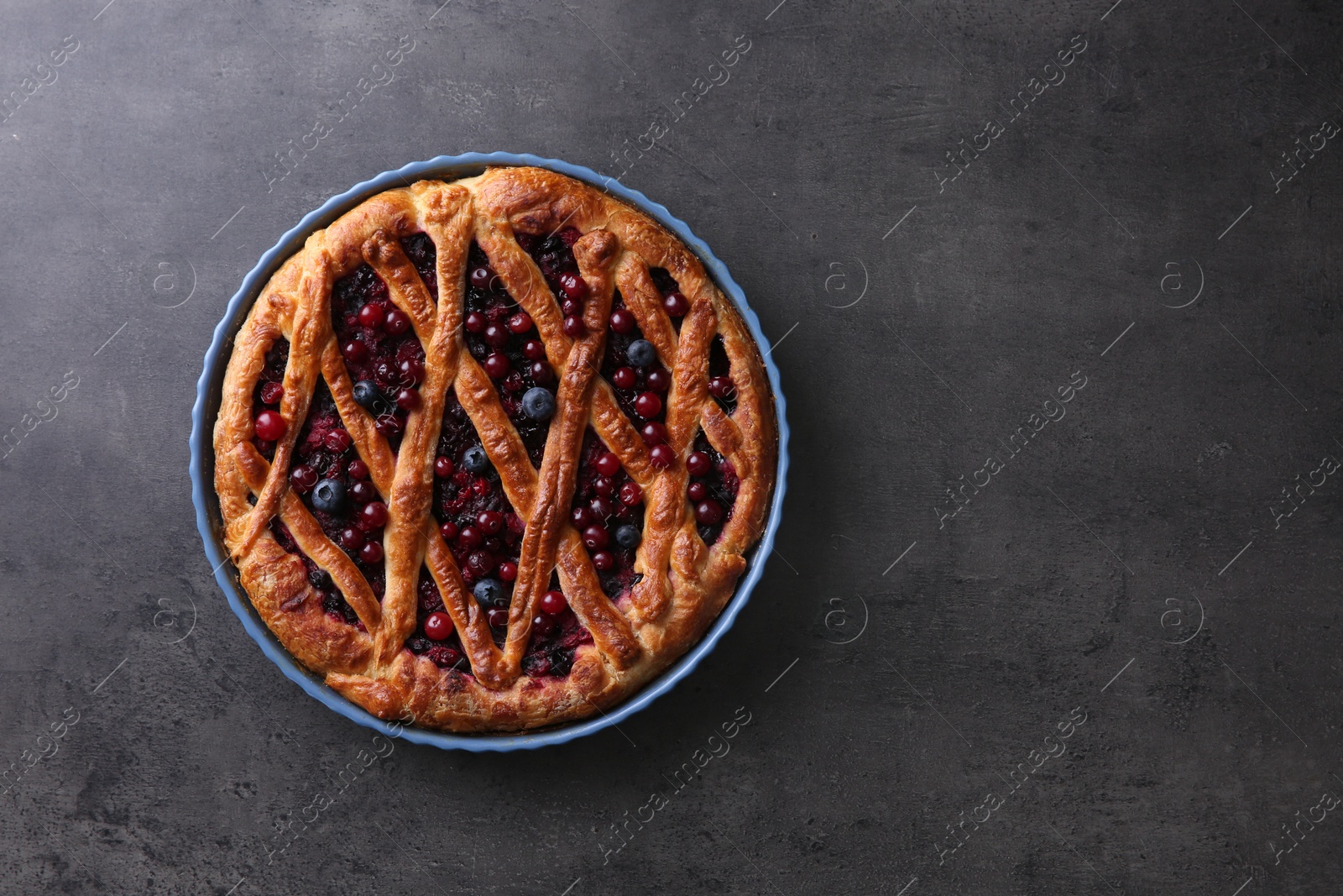 Photo of Delicious currant pie and fresh berries on grey table, top view. Space for text