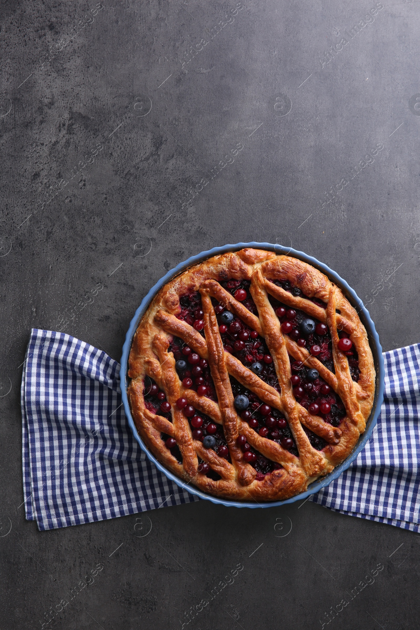 Photo of Delicious currant pie and fresh berries on grey table, top view. Space for text