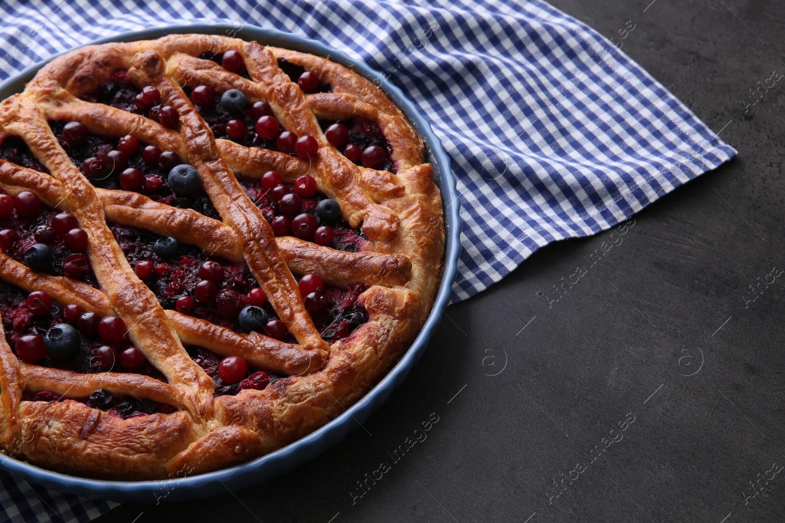 Photo of Delicious currant pie and fresh berries on grey table