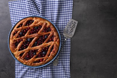 Photo of Delicious currant pie and fresh berries on grey table, flat lay. Space for text