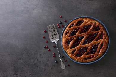 Photo of Delicious currant pie and fresh berries on grey table, flat lay. Space for text