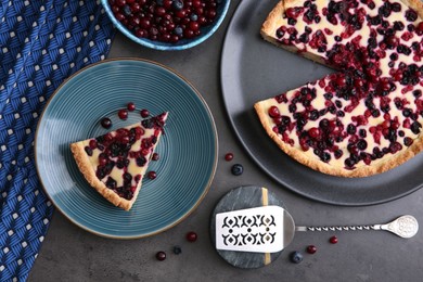 Photo of Delicious currant pie and fresh berries on grey table, flat lay