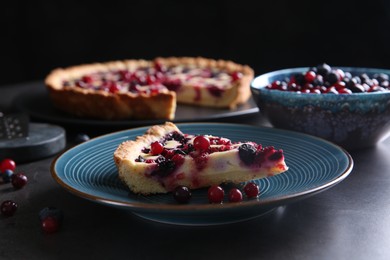 Photo of Piece of delicious currant pie and fresh berries on grey table, closeup