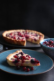 Photo of Piece of delicious currant pie and fresh berries on grey table, space for text