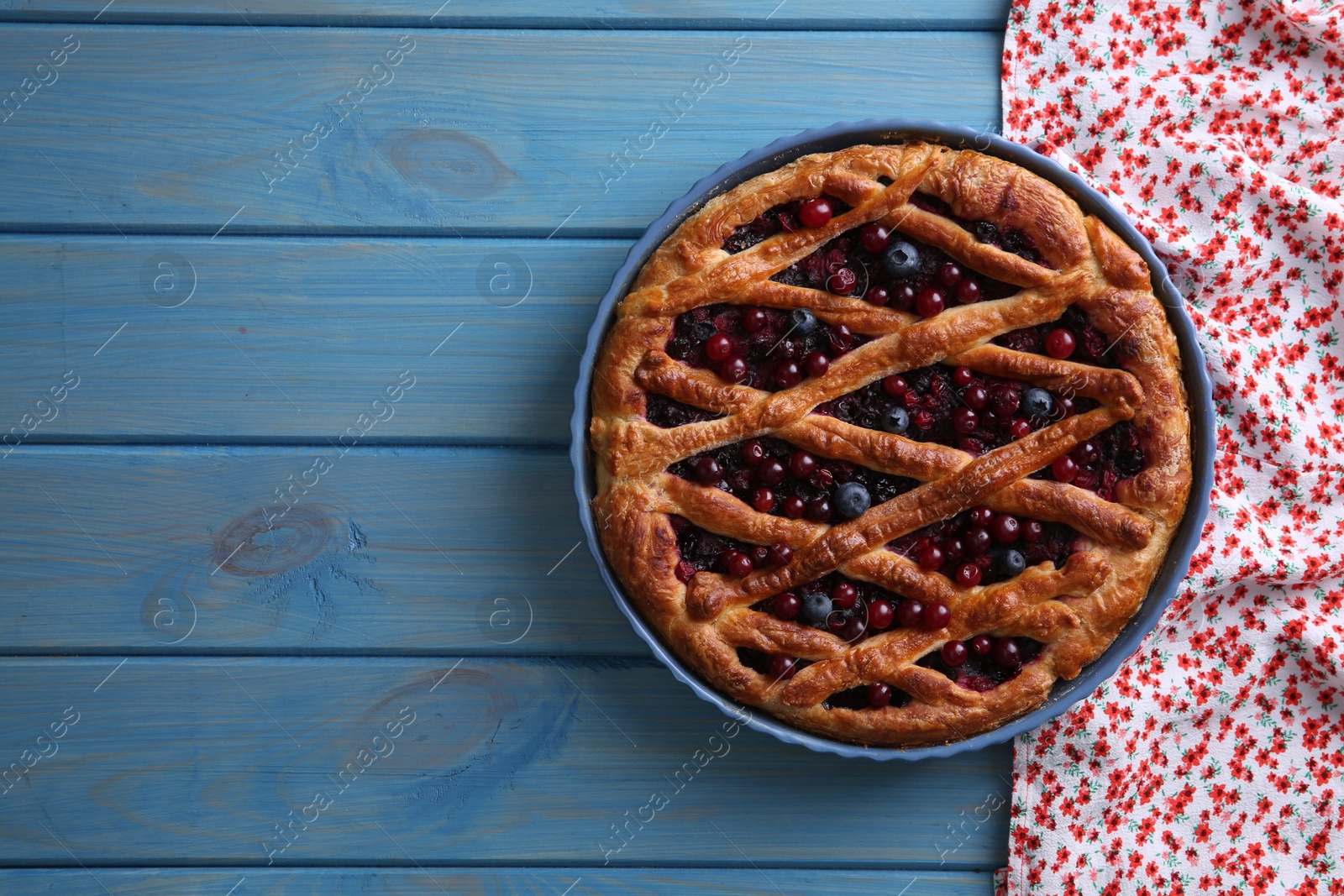 Photo of Delicious currant pie and fresh berries on blue wooden table, top view. Space for text