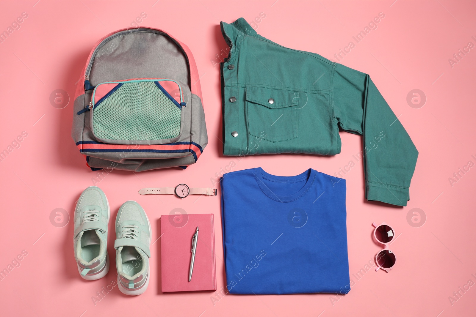 Photo of Stylish outfit with backpack on pink background, flat lay