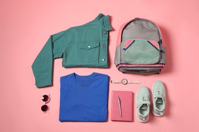 Photo of Stylish outfit with backpack on pink background, flat lay