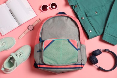 Photo of Stylish outfit with backpack on pink background, flat lay