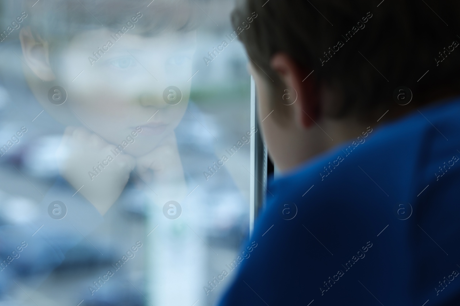 Photo of Autism concept. Lonely little boy near window at home, space for text