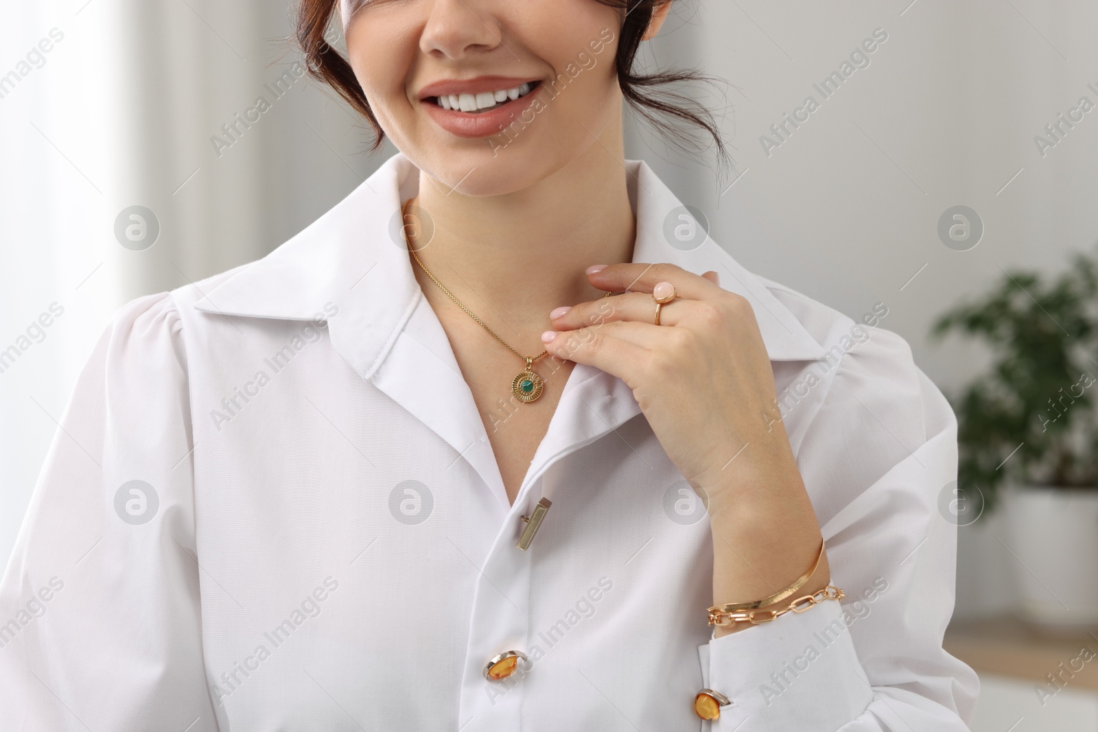 Photo of Young woman wearing elegant jewelry indoors, closeup