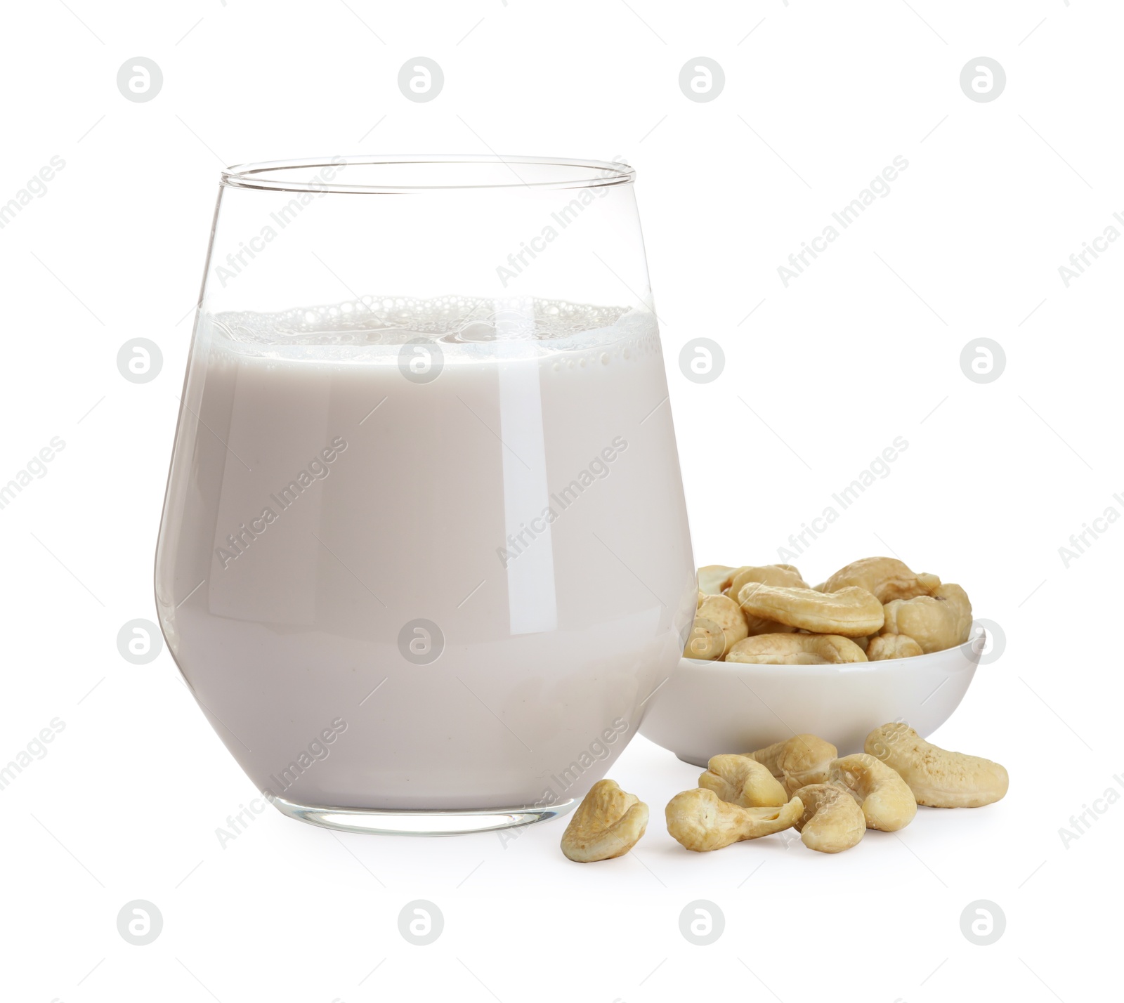 Photo of Fresh cashew milk in glass and nuts isolated on white