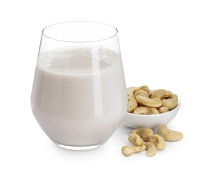 Photo of Fresh cashew milk in glass and nuts isolated on white