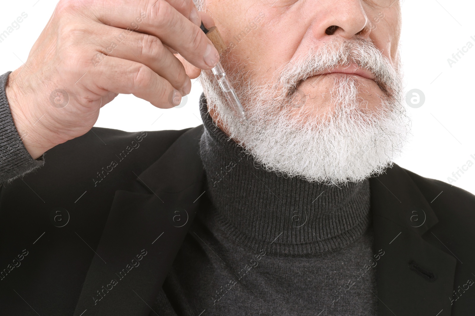 Photo of Senior man applying serum onto his beard on white background, closeup