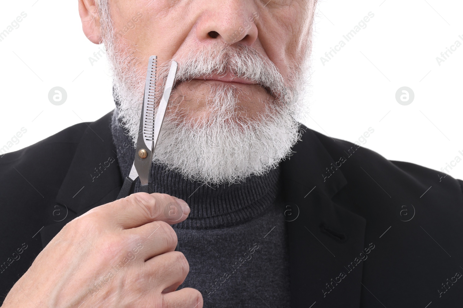 Photo of Senior man trimming beard with scissors on white background, closeup