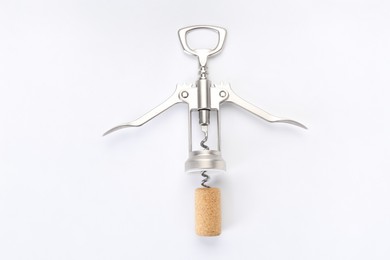 Photo of Wing corkscrew and cork on white background, top view