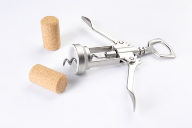 Photo of Wing corkscrew and corks on white background