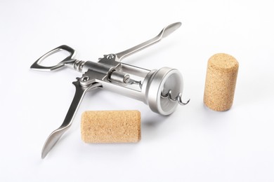 Photo of Wing corkscrew and corks on white background