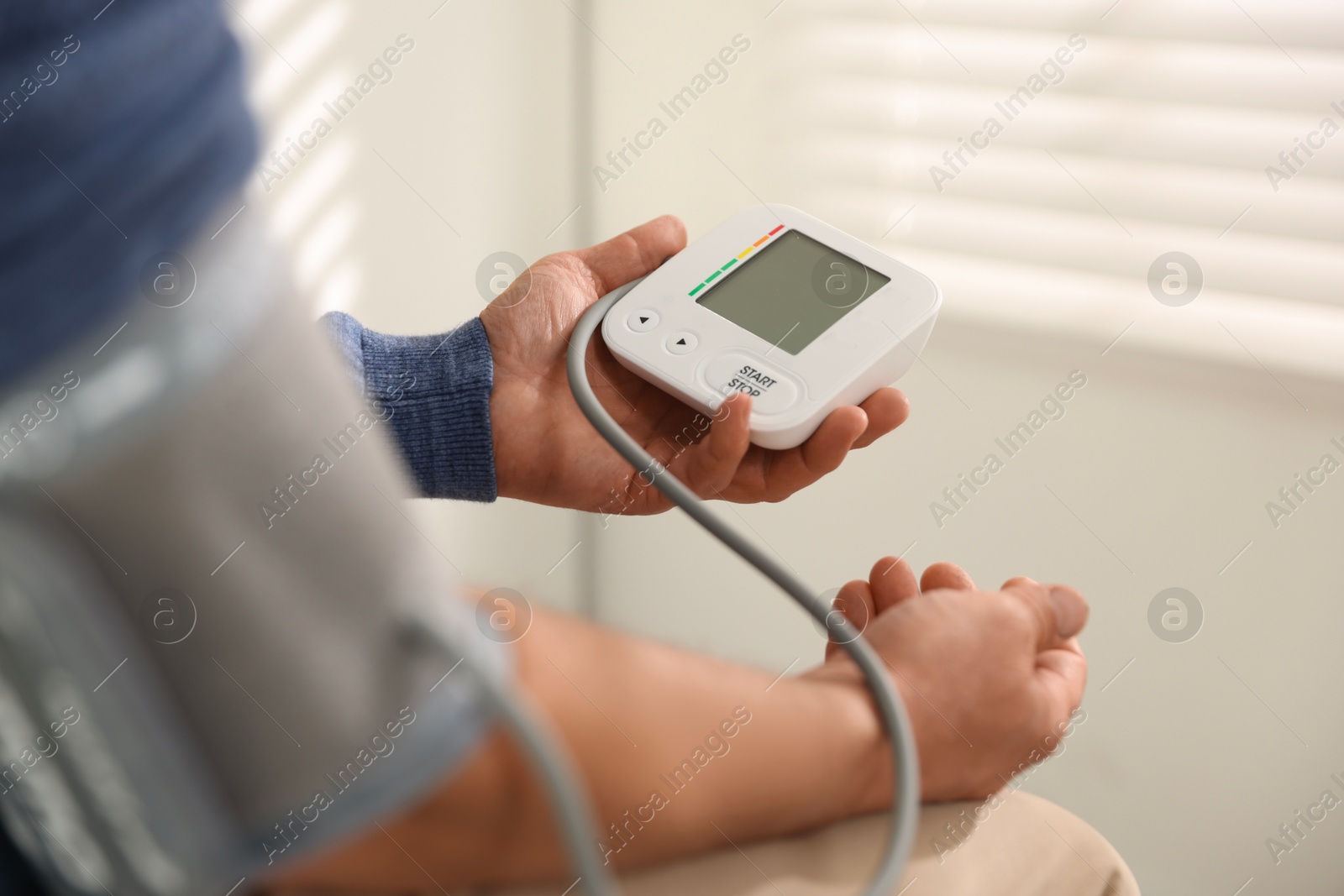 Photo of Senior man measuring blood pressure at home, closeup