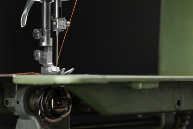 Photo of Professional sewing machine on blurred background, macro view