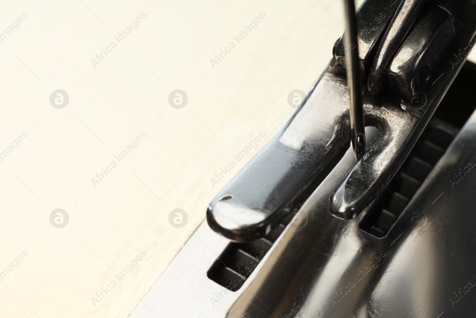 Photo of Macro view of sewing machine on table, space for text