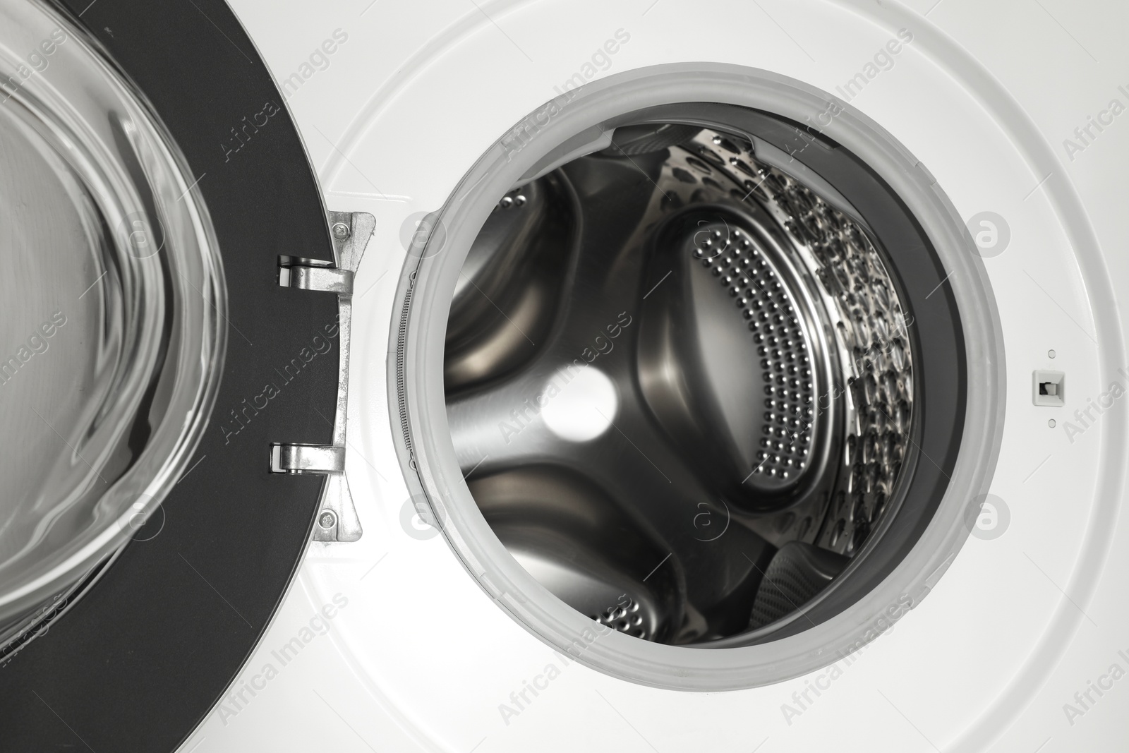 Photo of Washing machine with empty drum as background, closeup