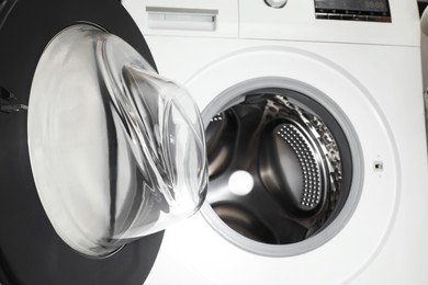 Photo of Washing machine with empty drum as background, closeup