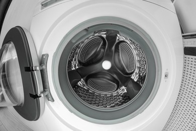 Photo of Washing machine with empty drum as background, closeup