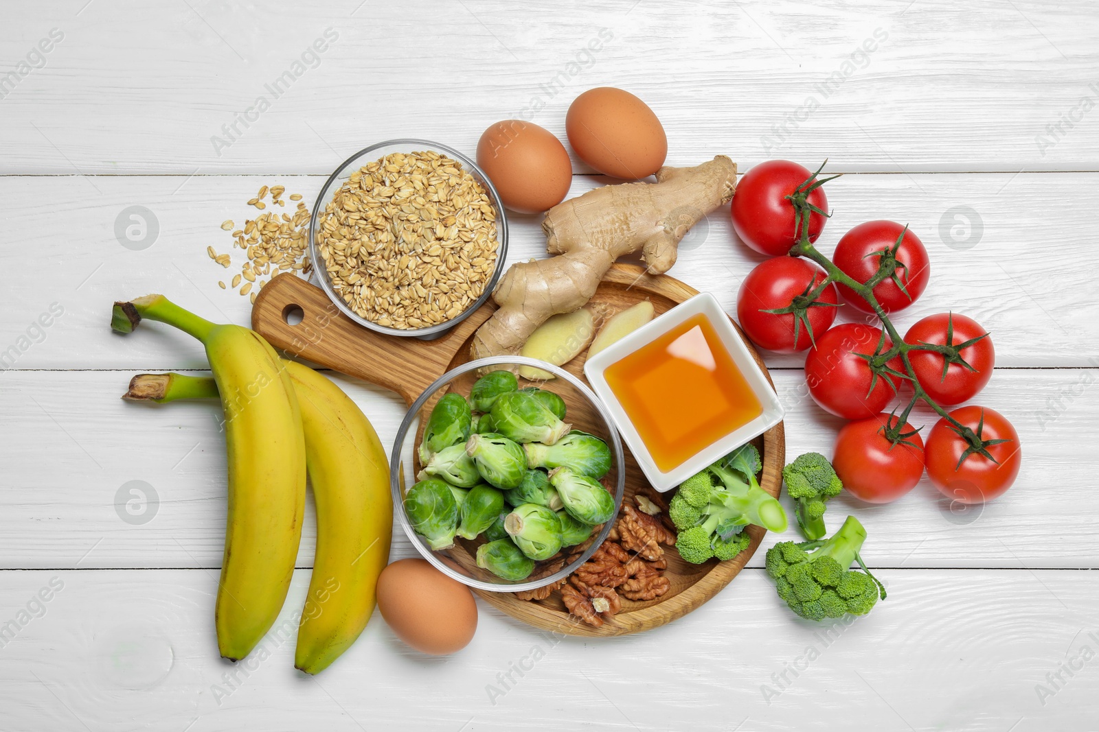 Photo of Different fresh products rich in melatonin on white wooden table, flat lay