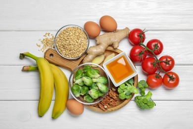 Photo of Different fresh products rich in melatonin on white wooden table, flat lay